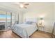 Cozy bedroom with plush bed, side table and lamp, hardwood floors, and shuttered window at 9900 Haze Dr, Venice, FL 34292