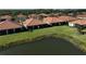 Aerial view of the community featuring single-Gathering homes with screened lanais overlooking a large pond at 9900 Haze Dr, Venice, FL 34292