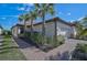 Charming single-story home featuring a well-kept lawn, neat landscaping, and a brick walkway at 9900 Haze Dr, Venice, FL 34292