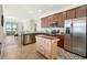 Well-lit kitchen features stainless appliances, island, and granite countertops with view to the lanai at 9900 Haze Dr, Venice, FL 34292