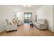 Bright living room with hardwood floors, neutral paint, and sliding doors to a screened lanai at 9900 Haze Dr, Venice, FL 34292