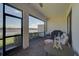 Relaxing screened-in patio with comfortable seating and a beautiful view of the lake at 9900 Haze Dr, Venice, FL 34292