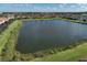 Scenic aerial view of a community pond surrounded by single-Gathering homes at 9900 Haze Dr, Venice, FL 34292