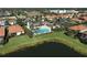 An aerial view of a community pool with blue water, surrounded by palm trees and well-manicured landscaping at 9900 Haze Dr, Venice, FL 34292