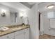 This bathroom features a granite countertop, vanity and a shower with white shower curtain at 1 Colony Point Dr # 11A, Punta Gorda, FL 33950