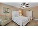 Cozy bedroom featuring a queen-sized bed, decorative pillows, chair, and tile flooring at 1 Colony Point Dr # 11A, Punta Gorda, FL 33950