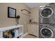 Laundry room featuring stacked washer/dryer, utility sink and folding table at 1 Colony Point Dr # 11A, Punta Gorda, FL 33950