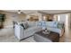 Bright living room featuring a large sectional, tile flooring, and seamless flow into dining and kitchen areas at 1 Colony Point Dr # 11A, Punta Gorda, FL 33950