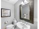 This bathroom has a decorative mirror, sink, and toilet, as well as a framed picture at 100 Central Ave # C619, Sarasota, FL 34236