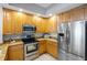 A well-lit kitchen features wooden cabinets, stainless steel appliances, and granite countertops at 100 Central Ave # C619, Sarasota, FL 34236