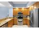 Bright kitchen showcasing wooden cabinets, granite counters, and stainless steel appliances at 100 Central Ave # C619, Sarasota, FL 34236