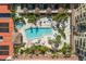 This is an aerial view of an outdoor pool surrounded by buildings, cabanas, and chairs at 100 Central Ave # C619, Sarasota, FL 34236