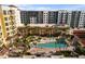 An aerial view of an outdoor pool surrounded by buildings and palm trees on a sunny day at 100 Central Ave # C619, Sarasota, FL 34236