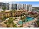 This outdoor pool is surrounded by buildings, palm trees, and chairs with blue cushions at 100 Central Ave # C619, Sarasota, FL 34236