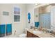 Well-lit bathroom featuring a vanity with granite countertop and decorative blue seahorse accent at 10412 Crooked Creek Dr, Venice, FL 34293
