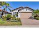 Charming single-story home featuring a well-manicured lawn, brick driveway, and a two-car garage at 10412 Crooked Creek Dr, Venice, FL 34293