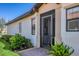 Charming front entry with a screened door, lush landscaping and brick walkway at 10412 Crooked Creek Dr, Venice, FL 34293