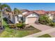 Lovely home exterior featuring a brick driveway, two car garage, and beautifully landscaped yard at 10412 Crooked Creek Dr, Venice, FL 34293