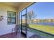 Open-air lanai featuring views of a lake, lush greenery and nearby buildings at 10412 Crooked Creek Dr, Venice, FL 34293