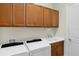 Bright laundry room with white washer and dryer and ample cabinet space at 10412 Crooked Creek Dr, Venice, FL 34293