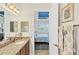 This bathroom features granite counters, dual sinks, and an open doorway to the main bedroom at 10412 Crooked Creek Dr, Venice, FL 34293