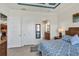 Comfortable main bedroom showcasing tile flooring, a blue ceiling, and access to the ensuite bathroom at 10412 Crooked Creek Dr, Venice, FL 34293
