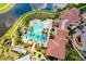 Aerial view of a community pool, clubhouse, and lake creating a resort-style atmosphere at 10742 Ironbridge Dr, Venice, FL 34293