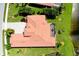 Aerial view of a red-tiled roof with manicured green grass and some palms at 10742 Ironbridge Dr, Venice, FL 34293