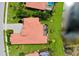 Aerial view of a home with a red tile roof next to a pond with manicured green lawns and lush landscaping at 10742 Ironbridge Dr, Venice, FL 34293