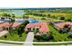 Beautiful aerial view of home with tile roof, complemented by lush landscaping and serene lake backdrop at 10742 Ironbridge Dr, Venice, FL 34293
