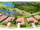 Aerial view of single Gathering homes near a scenic lake, golf course and lush green landscaping at 10742 Ironbridge Dr, Venice, FL 34293