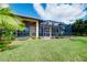 Backyard with a screened lanai and manicured lawn, ideal for outdoor enjoyment and relaxation at 10742 Ironbridge Dr, Venice, FL 34293