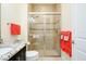 A bright bathroom featuring a glass-enclosed shower with tiled walls, granite countertops, and neutral colored walls at 10742 Ironbridge Dr, Venice, FL 34293