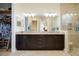 Elegant bathroom features dual sinks, dark wood cabinetry and walk in shower at 10742 Ironbridge Dr, Venice, FL 34293