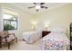 Charming bedroom with two twin beds, window view, and ceiling fan at 10742 Ironbridge Dr, Venice, FL 34293