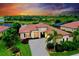 Stunning sunset view of a single-Gathering home featuring tile roof, paver driveway, and lush landscaping at 10742 Ironbridge Dr, Venice, FL 34293
