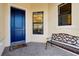 Charming front entrance with a blue front door, paver flooring, bench, and a decorative window at 10742 Ironbridge Dr, Venice, FL 34293