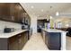 Modern kitchen with dark wood cabinets, stainless steel appliances, and a spacious center island at 10742 Ironbridge Dr, Venice, FL 34293