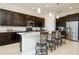 Open kitchen with dark cabinetry, granite countertops, and a breakfast bar with seating at 10742 Ironbridge Dr, Venice, FL 34293