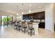 Gourmet kitchen with dark cabinets, a large island, and seamless flow into the dining area at 10742 Ironbridge Dr, Venice, FL 34293