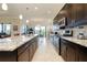 Spacious kitchen with long island, granite counters, stainless appliances, and view to living and dining areas at 10742 Ironbridge Dr, Venice, FL 34293