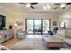 Bright living room leading to outdoor seating through sliding glass doors with ceiling fans and tile floors at 10742 Ironbridge Dr, Venice, FL 34293