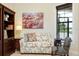 Cozy living room featuring a floral sofa and matching chair, next to a built-in bookcase at 10742 Ironbridge Dr, Venice, FL 34293