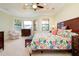 Comfortable main bedroom features tray ceilings, large windows, and a floral comforter at 10742 Ironbridge Dr, Venice, FL 34293