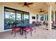 Covered patio with brick flooring, wrought iron table and chairs, and comfortable seating area overlooking the yard at 10742 Ironbridge Dr, Venice, FL 34293