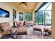 Enjoy outdoor living on this covered patio with comfortable seating, ceiling fan, and a view of the backyard at 10742 Ironbridge Dr, Venice, FL 34293