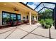 Spacious brick paved screened lanai featuring multiple seating areas and lush plants at 10742 Ironbridge Dr, Venice, FL 34293