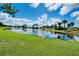 Scenic view of a tranquil pond reflecting the clear blue sky and scattered clouds at 10742 Ironbridge Dr, Venice, FL 34293
