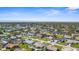 An aerial view of a charming home nestled in a sunny residential community with lush landscaping and nearby ocean at 1087 Piedmont Rd, Venice, FL 34293