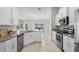 Bright kitchen features stainless steel appliances, granite counters, and tiled floors at 1087 Piedmont Rd, Venice, FL 34293